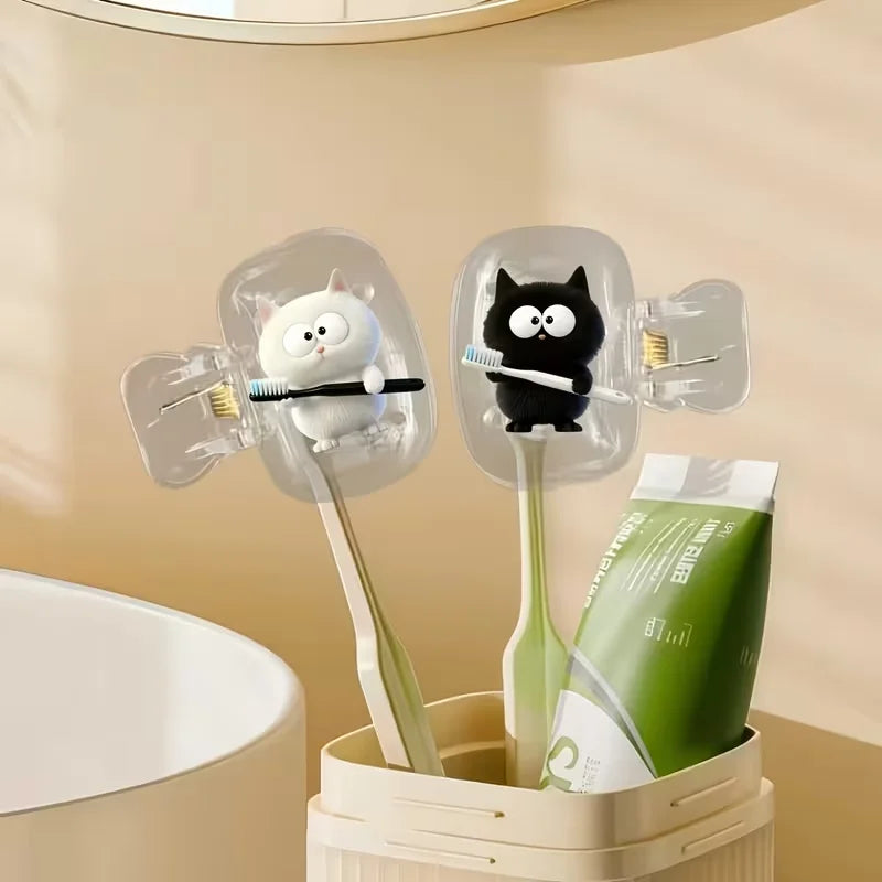Two white cat toothbrushes and a black cat toothbrush holder, a household toothbrush holder protective cover