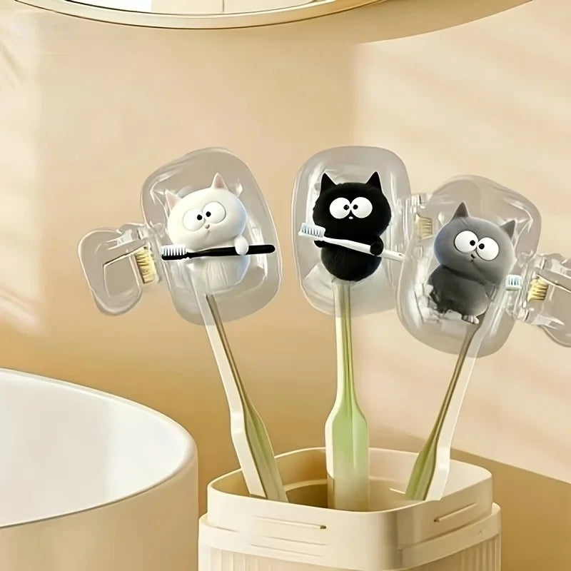 Two white cat toothbrushes and a black cat toothbrush holder, a household toothbrush holder protective cover